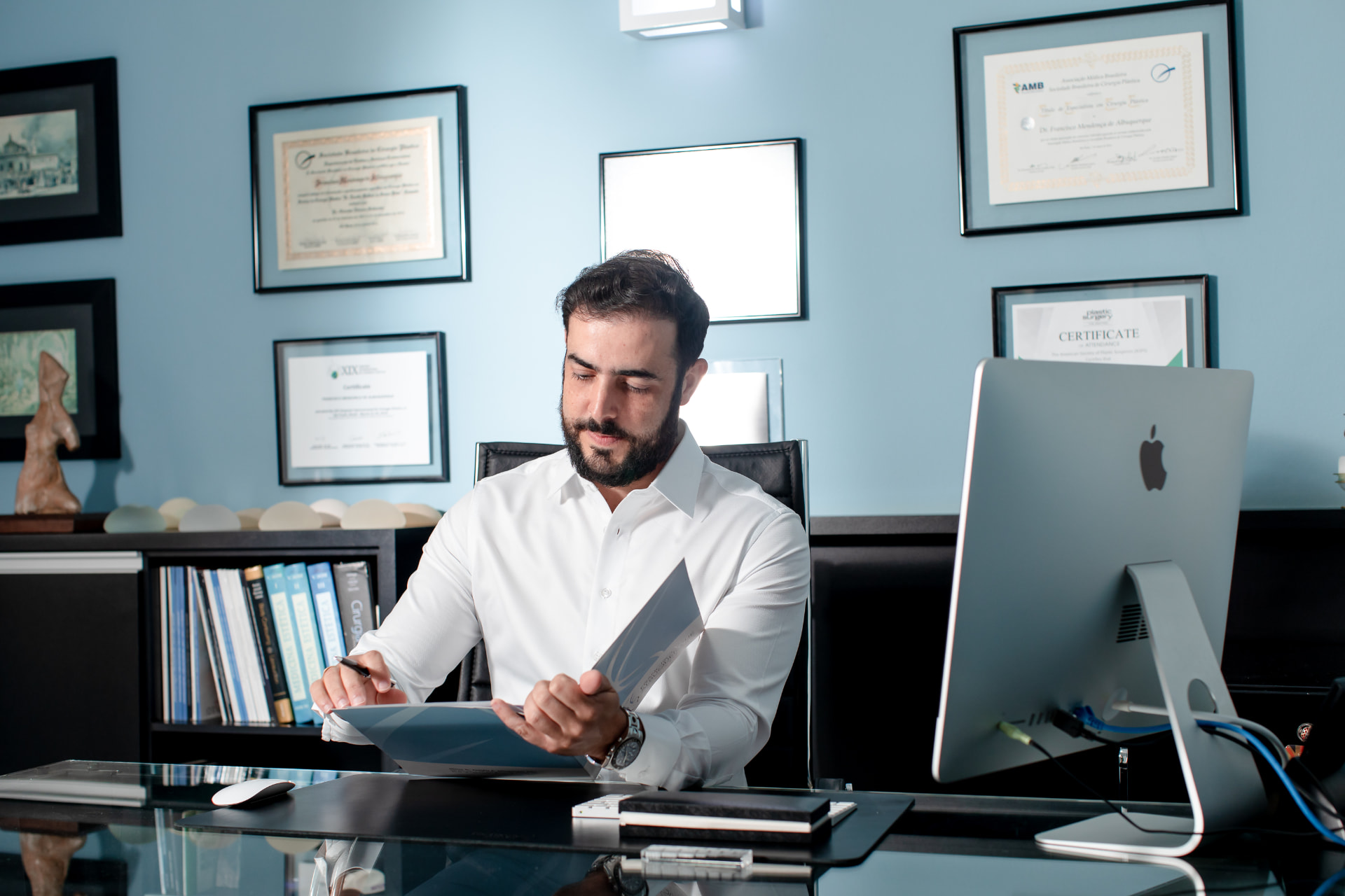 Dr. Francisco Albuquerque revisando documentos no consultório